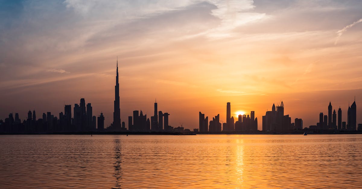 Enchanting view of Dubai's skyscrapers at sunset with the iconic Burj Khalifa outlined against the vivid sky.